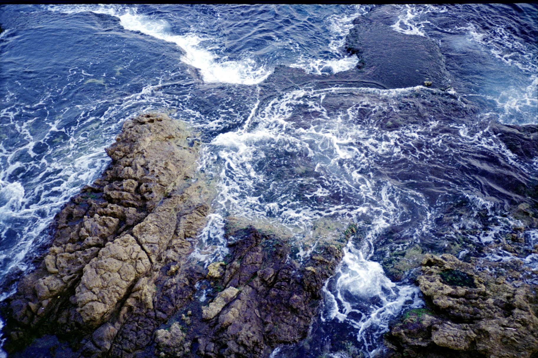 Ocean waves crashing over rugged coastal rocks